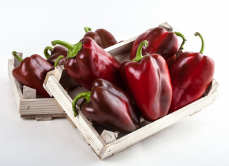 Red peppers group in two wooden boxes on white background