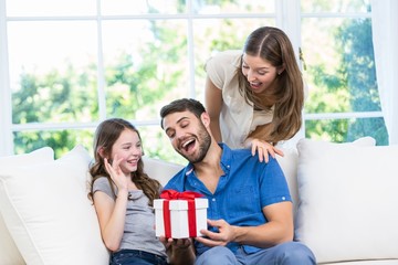 Wall Mural - Man surprised with gift given by family 