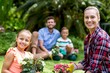 © WavebreakMediaMicro - Smiling mother and daughter with flower pots in yard