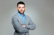 © Drobot Dean - Serious businessman standing with arms folded