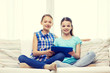 © Syda Productions - happy girls with tablet pc sitting on sofa at home