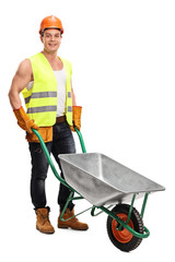 Wall Mural - Worker posing with an empty wheelbarrow