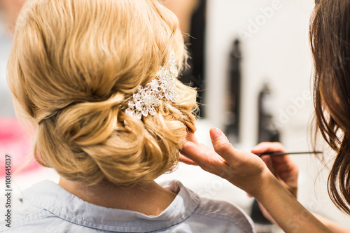 Obraz na plátně Hair stylist makes the bride before a wedding