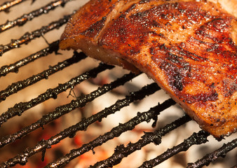 barbecued pork ribs with flames on the grill