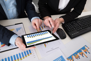 Wall Mural - Two Businesspeople Analyzing Graph On Digital Tablet