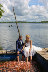 Wall Mural - bride and groom sitting with their feet in water