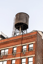 Water Tower Atop A Red Brick Building In Midtown Manhattan