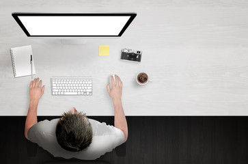 Sticker - man work on computer with white isolated screen. work desk with paper, camera, coffee, notepad, glas