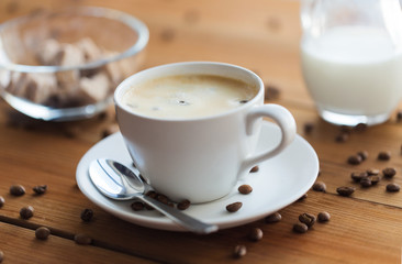 Wall Mural - close up coffee cup and grains on wooden table