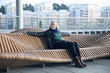 © Johnér - Woman sitting on modern bench
