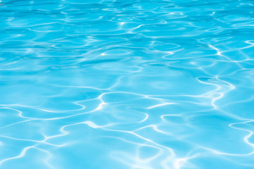beautiful gentle wave in swimming pool with sun reflection