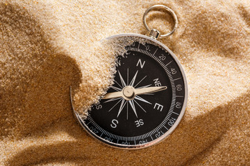 Black compass in beach sand