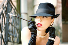 Outdoor Woman Portrait, Smoking A Cigarette With Cigarette Holder, Dressed In Hat And Pearl Jewelry