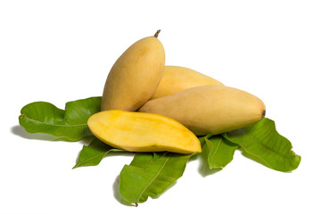 Wall Mural - Pile of mangoes on a green leaves on white background