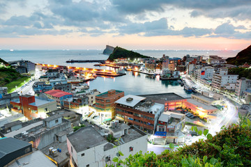 Wall Mural - Scenery of misty sunrise at Yehliu, a fishing village at dawn on northern coast of Taipei Taiwan ~ View of coast highway, harbor, coastline and a fishing village under dramatic dawning sky