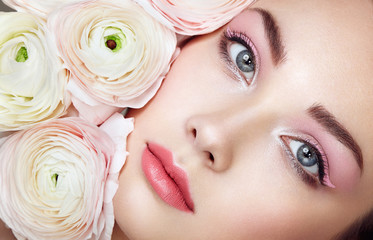 Wall Mural - Portrait of beautiful young woman with flowers. Brunette woman with luxury makeup. Perfect skin. Eyelashes. Cosmetic eyeshadow