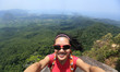 young woman hiker use smartphone taking self photo on seaside mountain top