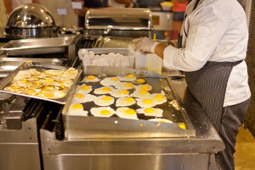 The cook is cooking an omelet for a breakfast