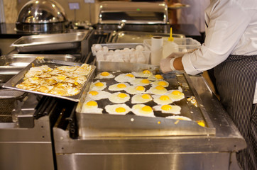 The cook is cooking an omelet for a breakfast