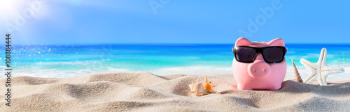 Fotomural Piggy Bank With Sunglasses On The Beach Holiday
