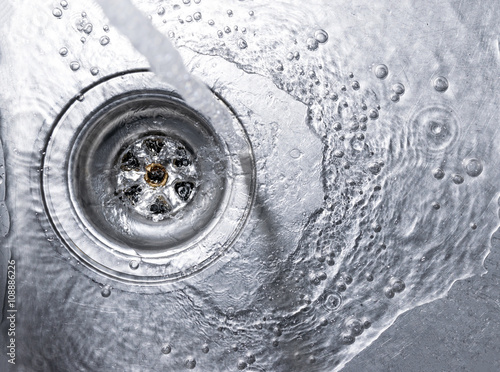 Fotografía Running water drains down a stainless steel sink