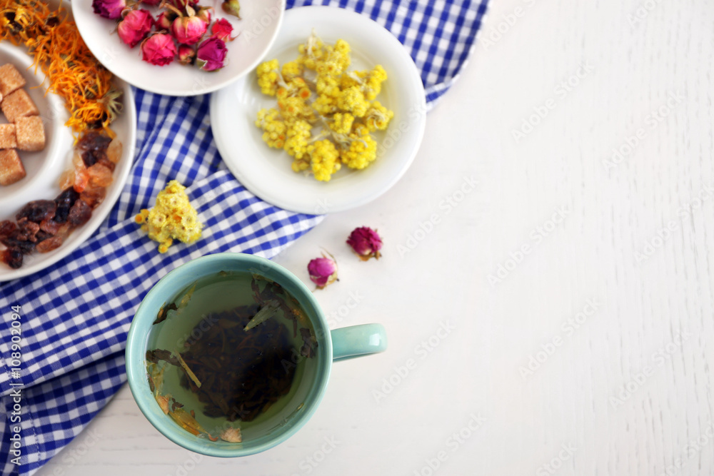 Cup of tea with aromatic dry tea on wooden background
