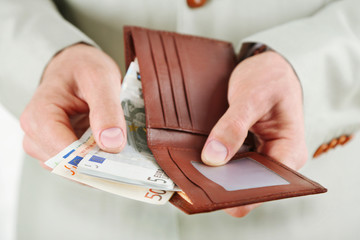 Poster - Male hands holding leather wallet with euros closeup