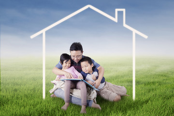 Happy family read book under house symbol