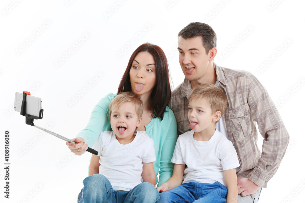 Happy family making selfie with selfie stick isolated on white