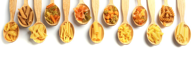 Different types of dry pasta in wooden spoons on white background