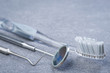 Basic dental tools and brush on grey surface