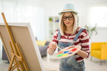 Wall Mural - Female artist mixing colors on a palette