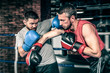 © belyjmishka - Boxers competition in the ring. Two athletes boxers sparred in the ring. One athlete in blue boxing gloves, the second in a red sports uniform.