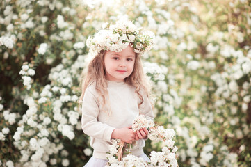 Wall Mural - Cute kid girl 3-4 year old wearing stylish clothes and holding basket with flowers outdoors. Childhood. Looking at camera. 