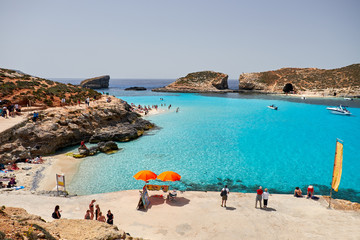 BLUE LAGOON, COMINO, MALTA - APRIL 13, 2016. People enjoy blue lagoon  with crystal clear blue water.