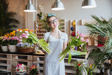 Cheerful Woman Florist Holding Two Bunches Of Pink Tulips