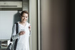 © Westend61 - Smiling woman looking on cell phone