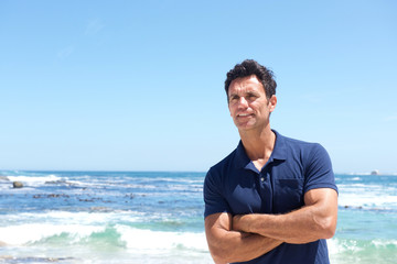 Wall Mural - Rugged middle aged man standing at the beach