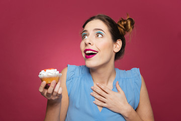 Portrait of smiling inspired young woman with cupcake