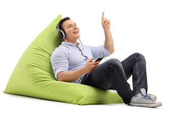 Wall Mural - Guy listening to music seated on beanbag