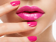 © Valua Vitaly - Closeup woman hand with pink nails near lips.