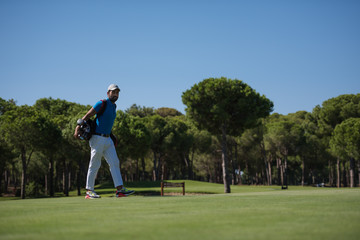 golf player walking and carrying bag