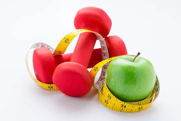 Fitness dumbbells and fruits. Fresh green tasty apple with measuring tape isolated on white