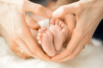 hand formt ein herz um baby füße
