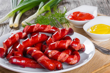 Poster - Grilled sausages on a white dish, close-up