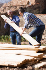 Wall Mural - workmen arranging building timber at farm