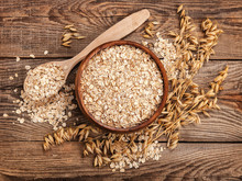 Oatmeal In A Bowl And Spoon Old Board On Top. Spikes Of Oats