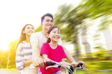 Canvas Print - Happy asian family having fun in park with bicycle