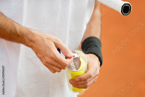 New balls. Tennis player opening can with new tennis balls Poster