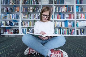 female student study in library, using tablet and searching for